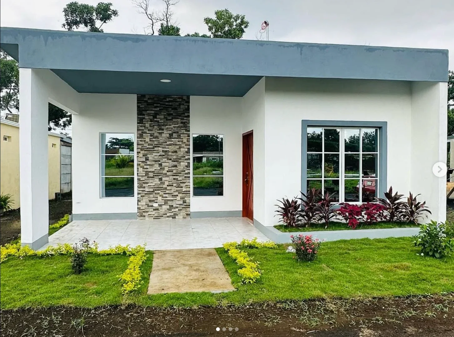 Casa blanca con losa gris, porche y columna de piedra